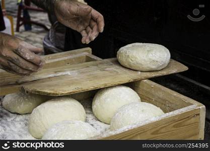 Bakers kneading bread dough in traditional way, artisan work detail, daily meal, healthy living