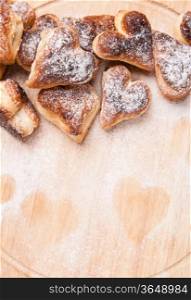 bakery hearts from split pastry with sugar powder on wooden board
