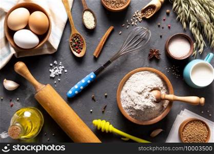 Bakery ingredients for homemade bread baking on table. Baker food set at stone background texture with copy space. Flat lay top view