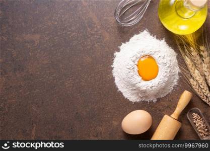 Bakery ingredients for homemade bread baking on table. Flour food and egg for recipe top view at stone background texture with copy space, flat lay concept
