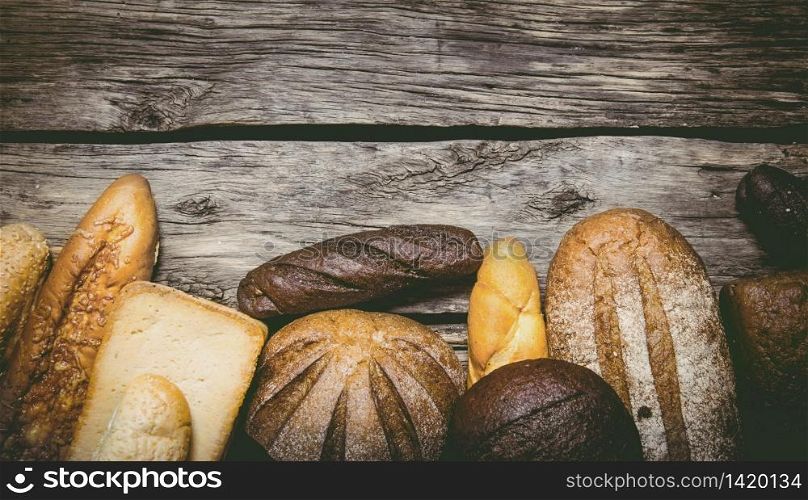 Bakery products on the wooden background. Free space for text . Top view. Bakery products on wooden background.