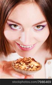 Bakery sweet food and people concept. Smiling woman holds cake cupcake in hand high angle view orange background