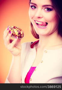 Bakery, sweet food and people concept. Woman enjoying cake cupcake licking lips orange background