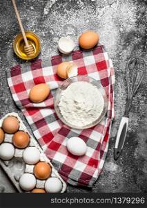 Baking background. Flour and fresh eggs for baking on rustic background .