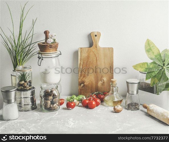 Baking background of savory with kitchen utensils, rolling pin , flour, ingredients and fresh vegetables at white wall . Sustainable lifestyle. Front view.