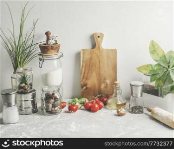 Baking background of savory with kitchen utensils, rolling pin , flour, ingredients and fresh vegetables at white wall . Sustainable lifestyle. Front view.