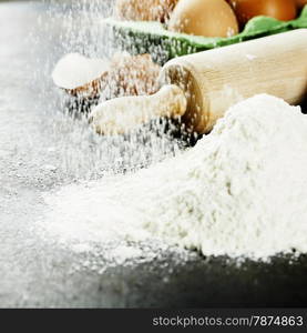 baking background with raw eggs, rolling pin and flour