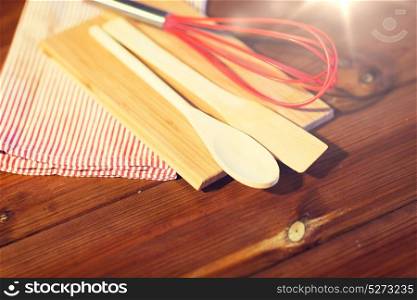 baking, cooking and home kitchen concept - close up of kitchenware and towel set on wooden board. close up of cooking kitchenware on wooden board