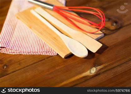 baking, cooking and home kitchen concept - close up of kitchenware and towel set on wooden board