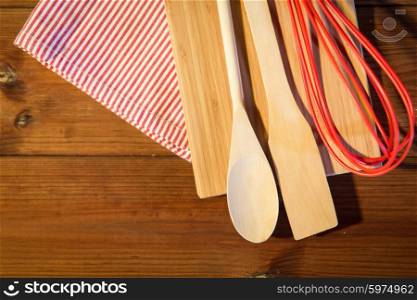 baking, cooking and home kitchen concept - close up of kitchenware and towel set on wooden board
