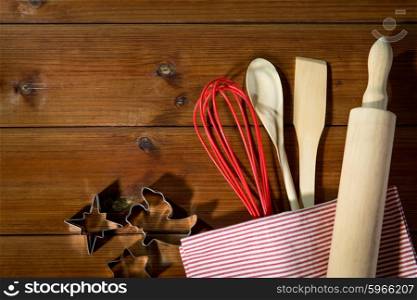 baking, cooking, christmas and home kitchen concept - close up of kitchenware set for baking gingerbread on wooden board from top