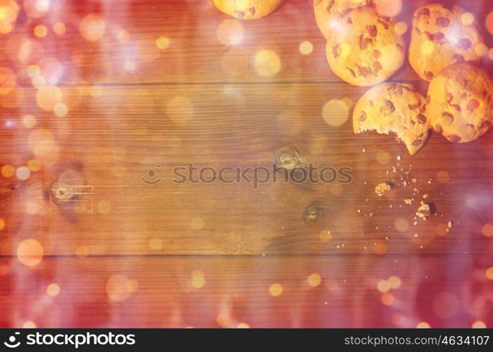 baking, cooking , christmas, holidays and food concept - close up of oat cookies on wooden table over lights