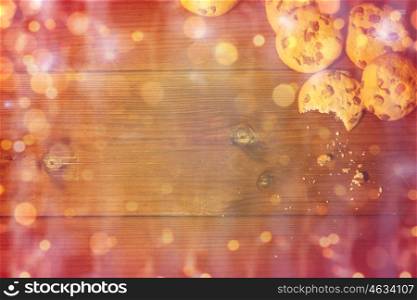 baking, cooking , christmas, holidays and food concept - close up of oat cookies on wooden table over lights