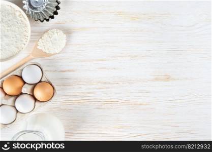 Baking cooking Ingredients background with copy space. Flour, eggs, milk, bakeware on white wooden surface. Top view, flat lay. Mockup menu, banner, header for site, baking concept