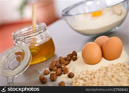 Baking dough ingredients, honey, eggs, flour in kitchen