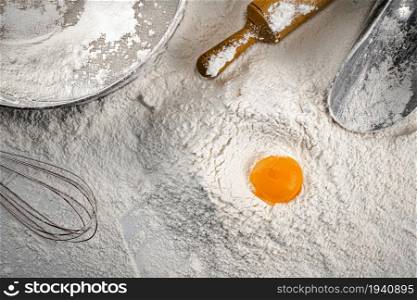 Baking. Egg in a bunch of flour. On a white background. . Baking. Egg in a bunch of flour.