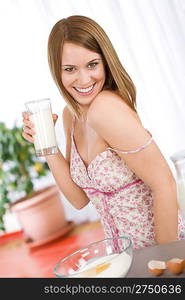 Baking - Happy woman tasting healthy ingredient for organic bread dough, with milk