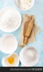 Baking ingredients on a blue table background. Ingredients for baking a cake, cookies or pastry.  Food background