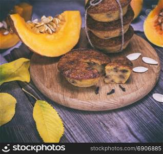 baking muffins from a pumpkin on a wooden board, vintage toning