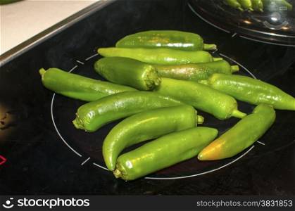 Baking of green chilies on ceramic hot plate cooker