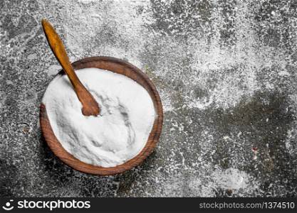 Baking soda in a bowl. On rustic background.. Baking soda in a bowl.