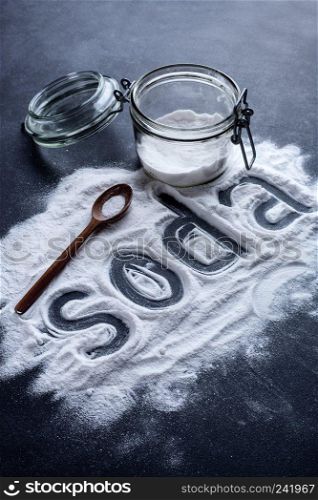 baking soda scattered from a glass jar on a dark background