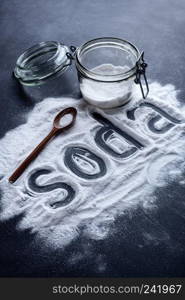 baking soda scattered from a glass jar on a dark background