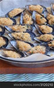 Baking tin full of tasty mussels au gratin