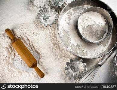 Baking. Wooden rolling pin and sieve. Top view. On a white background.. Baking. Wooden rolling pin and sieve. Top view.