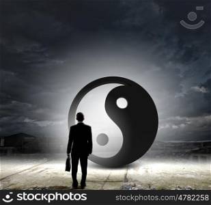 Balance concept. Rear view of businessman looking at yin yang sign