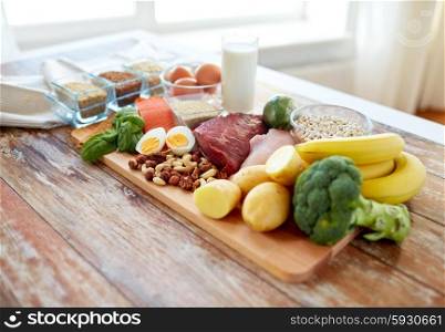 balanced diet, cooking, culinary and food concept - close up of vegetables, fruit and meat on wooden table