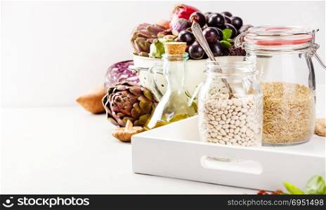 Balanced diet, cooking, vegetarian, raw and clean eating concept - close up of fresh organic fruits and vegetables, grains, legumes and nuts on concrete background with space for text. Healthy food concept