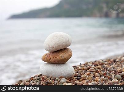 balanced stone pyramid standing on the beach of sea