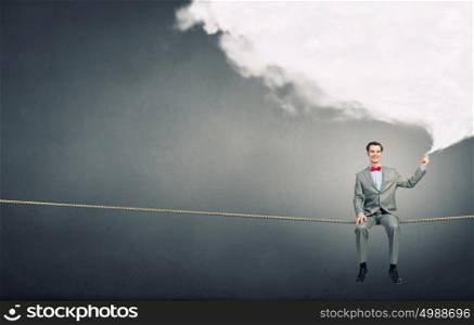 Balancing on rope. Young confident businessman sitting on rope with cloud balloon