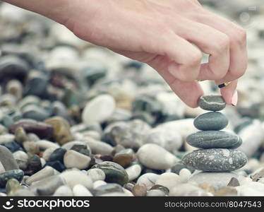 balancing pebble tower with female hand