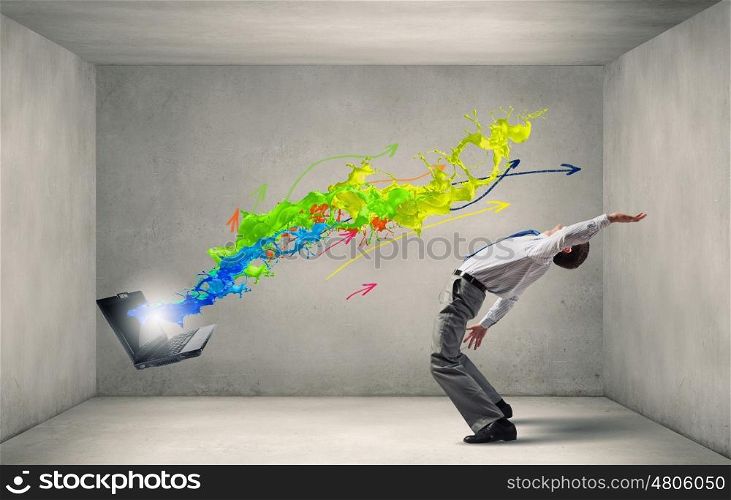 Balancing young man evading from explosion of ideas. Businessman evades splash ideas