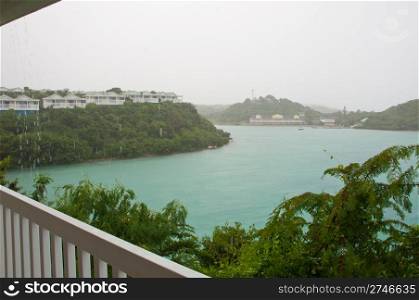 balcony view of Long Bay with resort villas and seascape in Antigua (tropical storm, rainy weather)