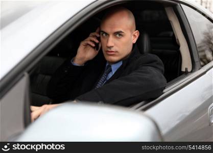 Bald businessman making call from car