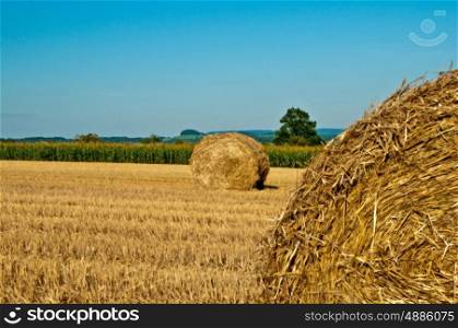 bale of straw with a panoramic view to a hill. grain harvest