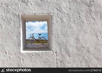 Balearic islands beach and bicycle view through whitewashed house window