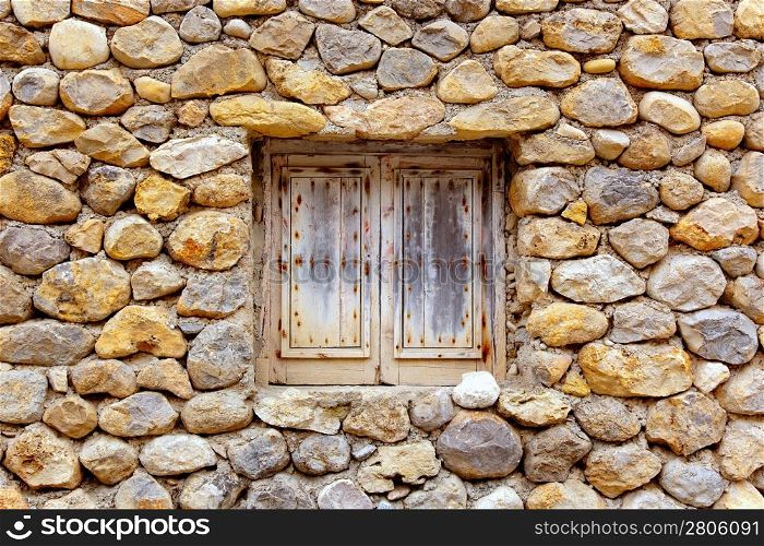 Balearic islands masonry stone wall with grunge wood window