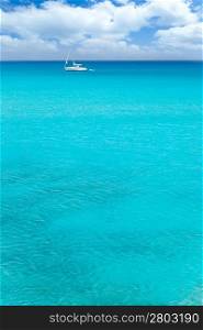 Balearic mediterranean turquoise sea with sailboat under blue sky