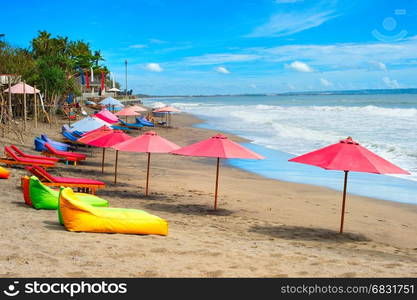 Bali beach with sacks, umbrellas and deck-chairs on the. Indonesia