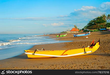 Balinese fisherman village at sunrise. Traditional Balinese fisherman boat on foreground