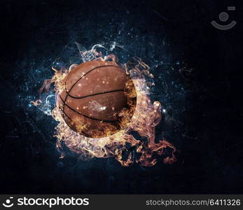 Ball in fire flames on dark background. Mixed media. Basketball game concept