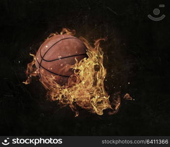 Ball in fire flames on dark background. Mixed media. Basketball game concept