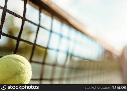 Ball in net closeup, big tennis concept, outdoor court. Professional game equipment