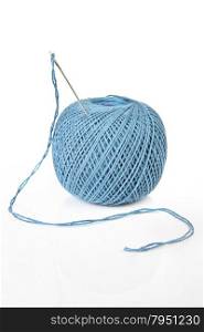Ball of blue cotton thread and sewing needle isolated on white background