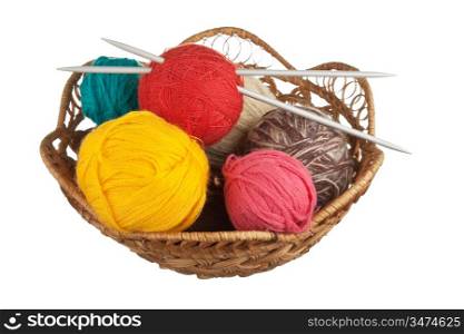 ball of wool and knitting needles in basket isolated on a white background
