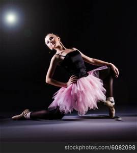 Ballerina dancing in the dark studio